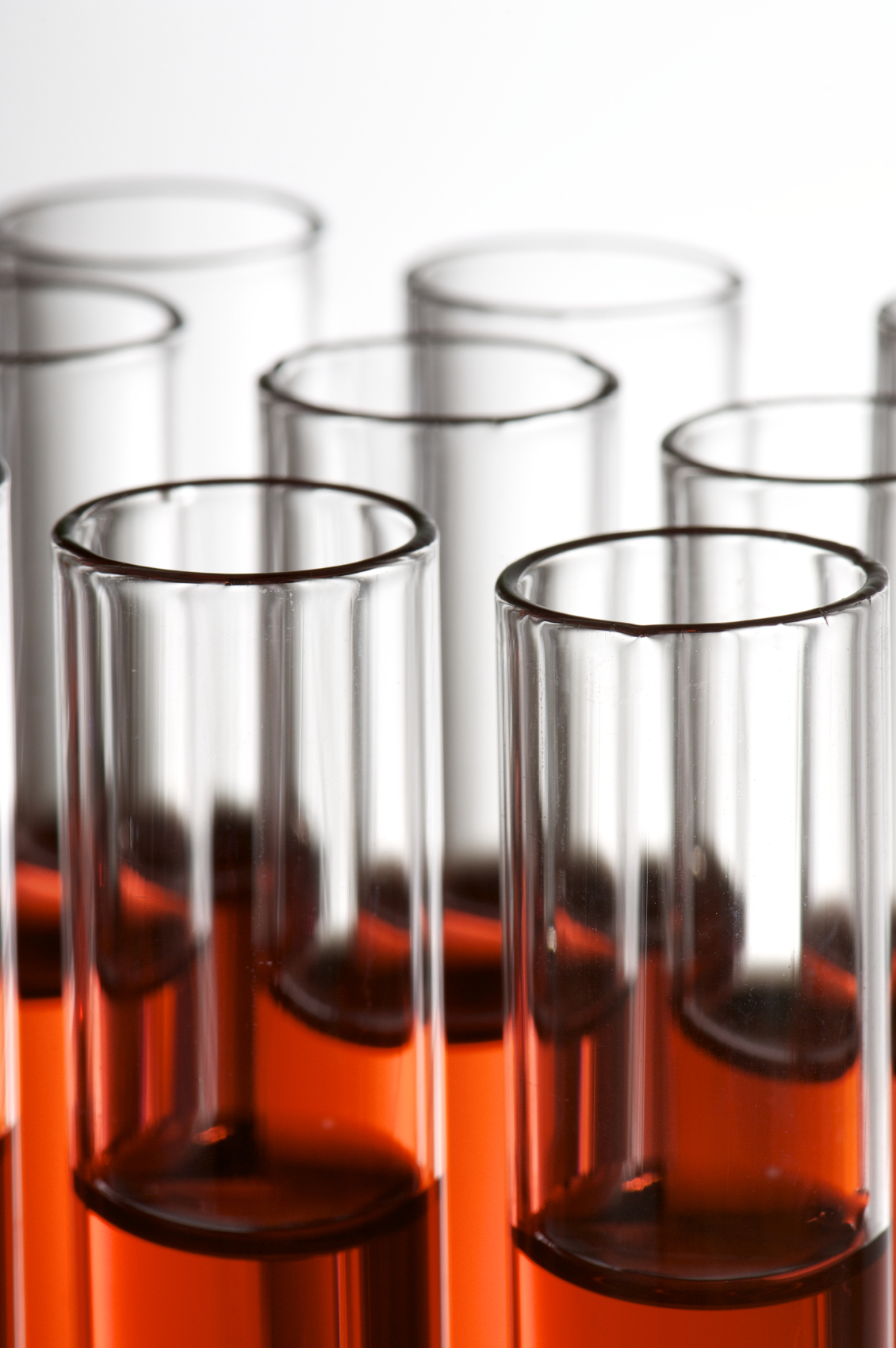 group of laboratory test tubes with red liquid inside