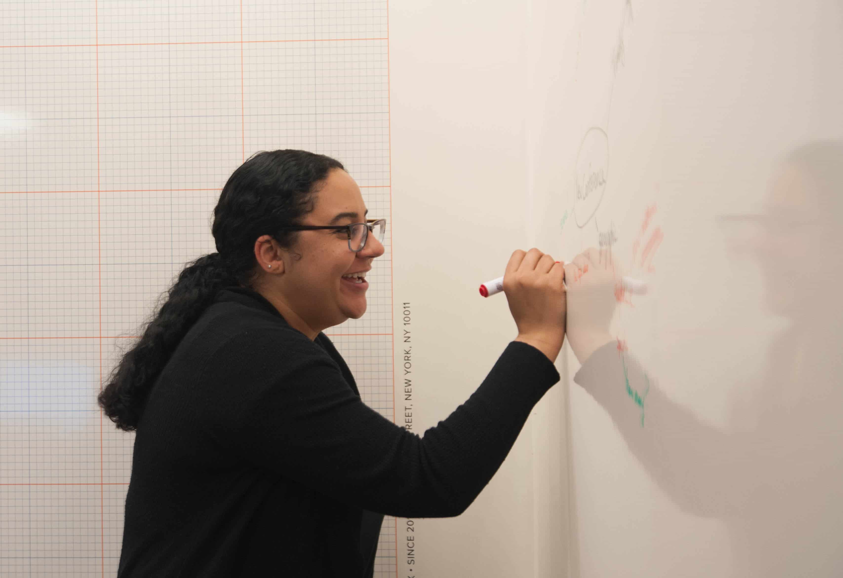 employee writing on whiteboard